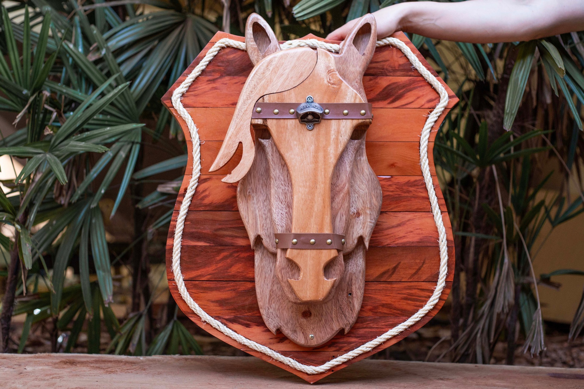 Brasão de madeira com cabeça de cavalo e detalhes em couro