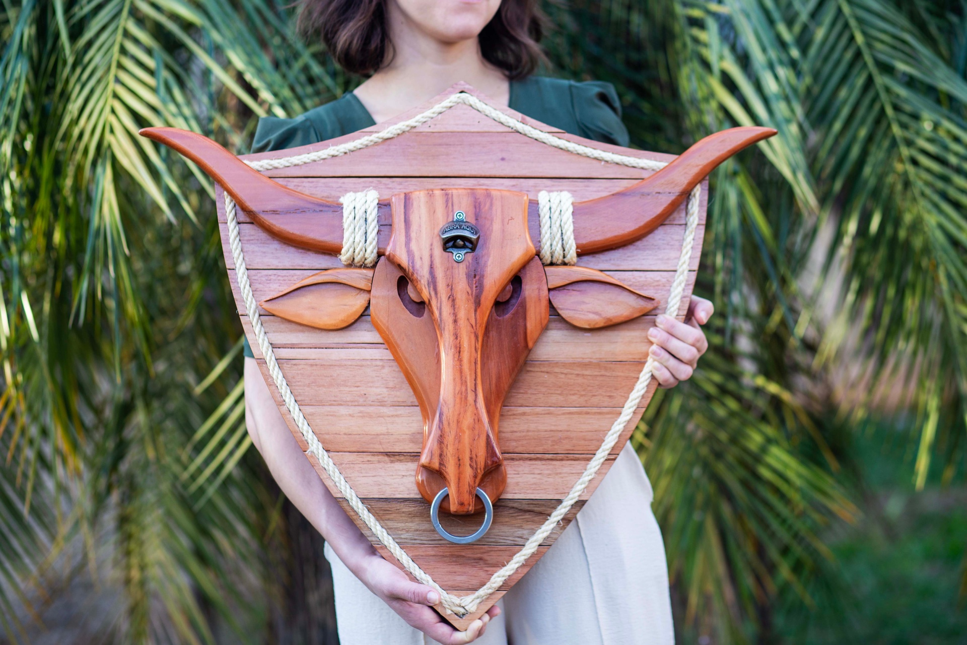 Cabeça de touro longhorn entalhada em madeira sobre brasão rústico